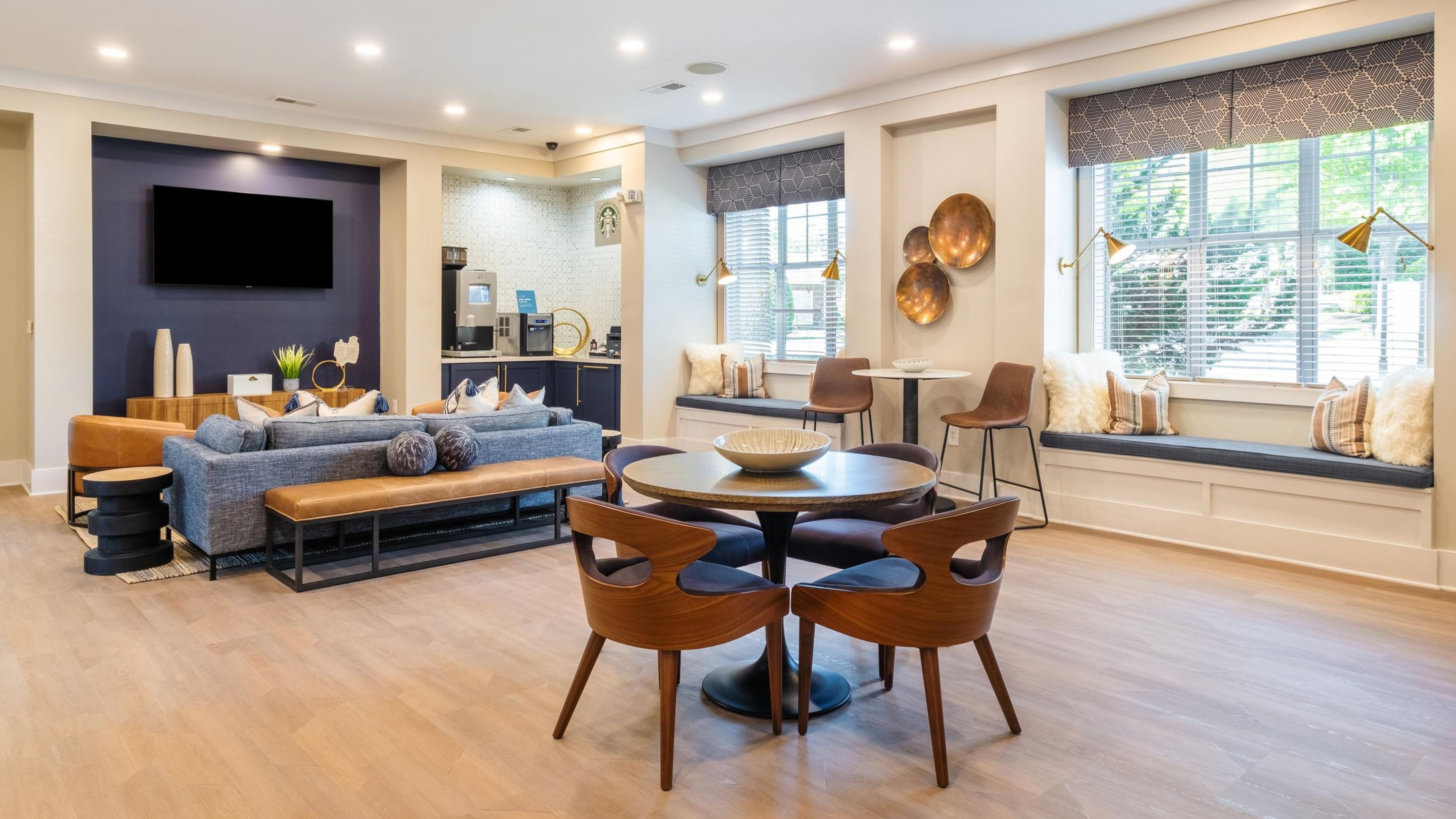 Hawthorne at the Greene gorgeous cyber cafe amenity for residents with spaces to work including tables, booth seating, and couches, and with a Starbucks coffee area in the corner of the room