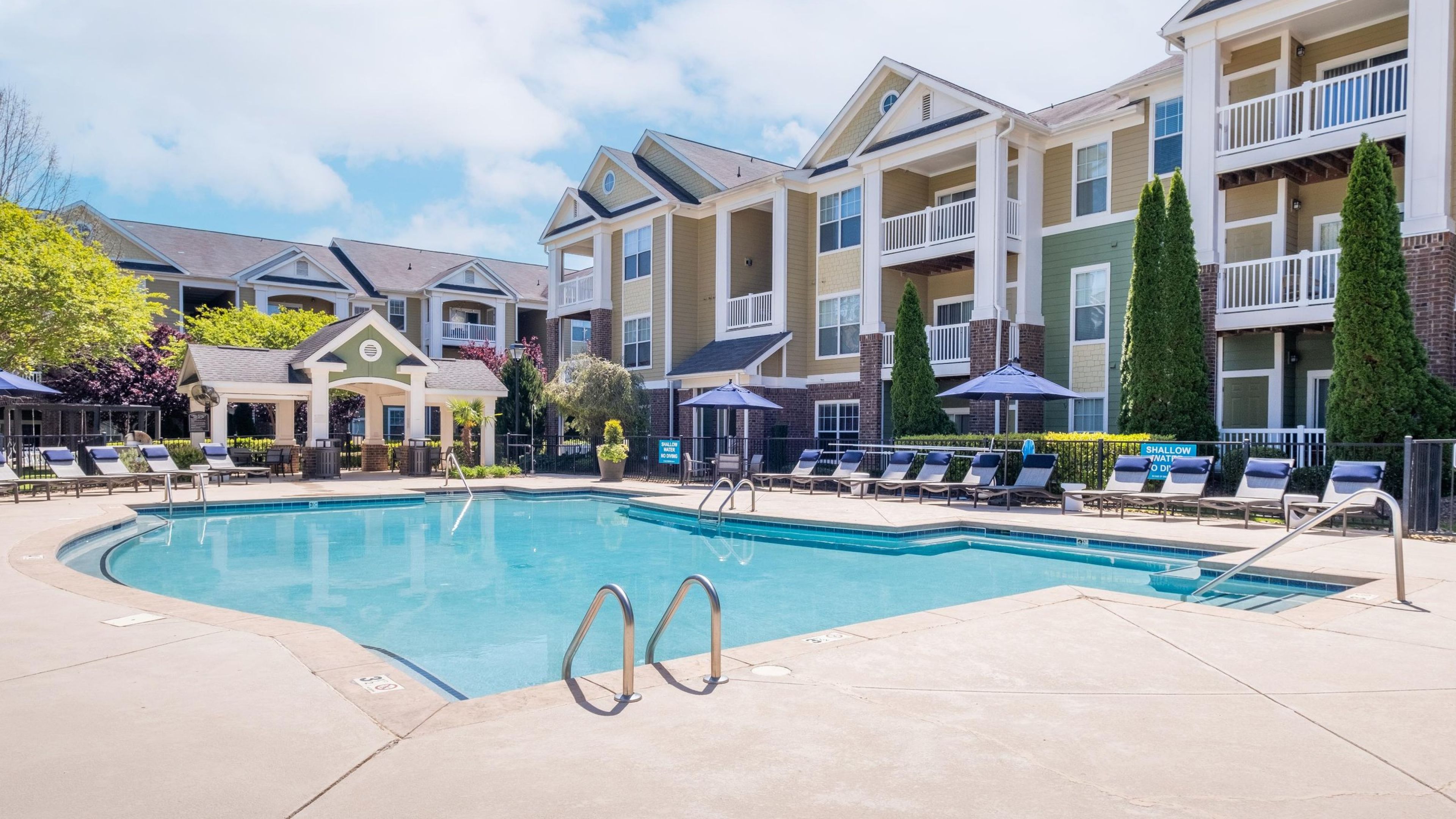 Hawthorne at the Greene outdoor pool with lounge seats, surrounded by apartment buildings